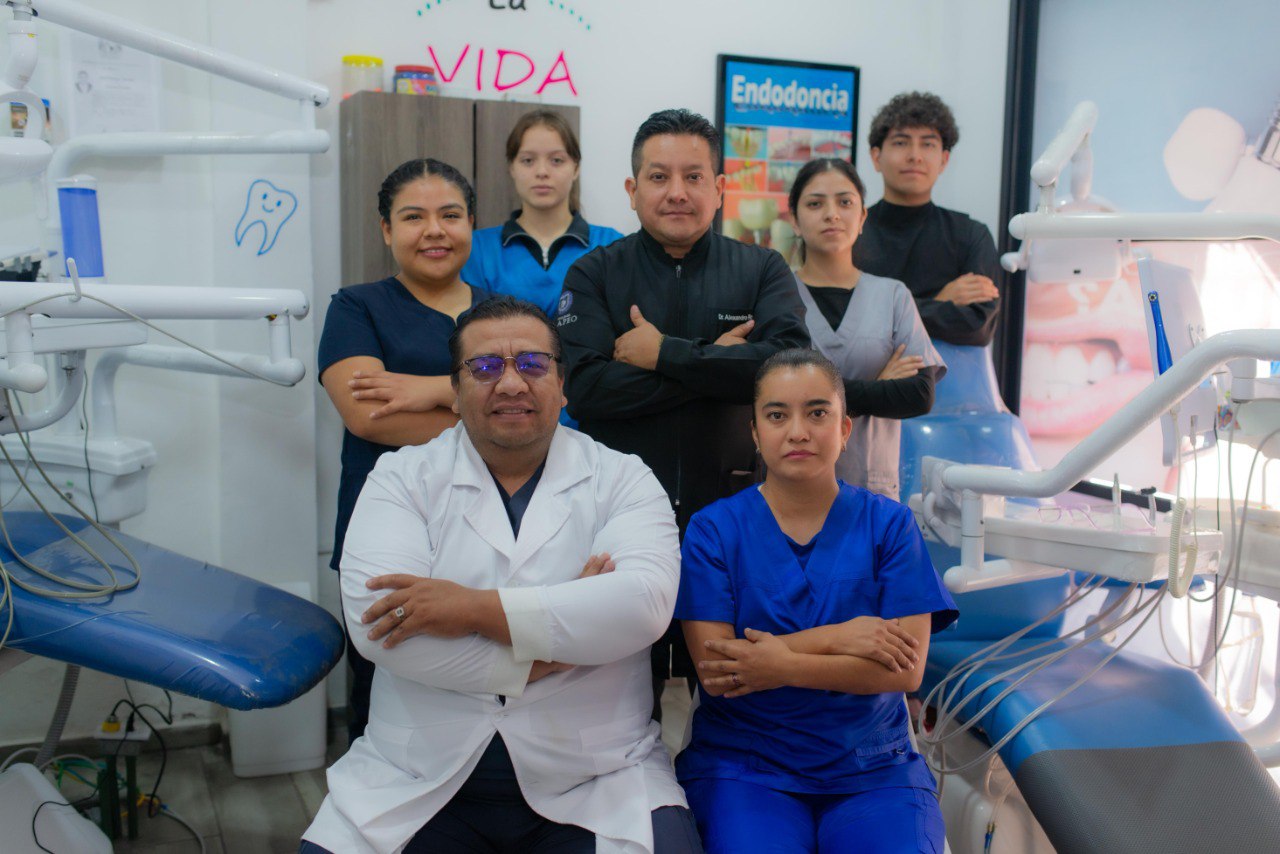 foto del equipo de arte dental en la clínica con bata blanca y sonriendo